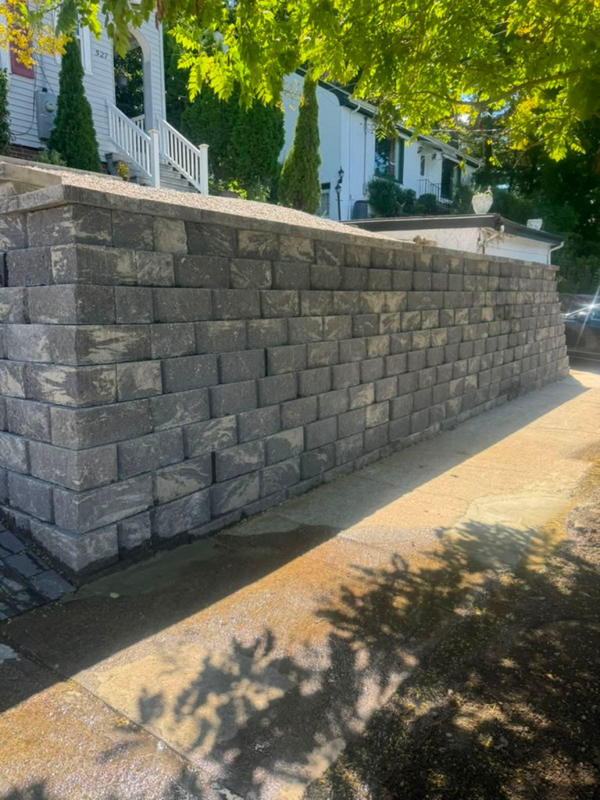 Charcoal block retaining wall along a sidewalk