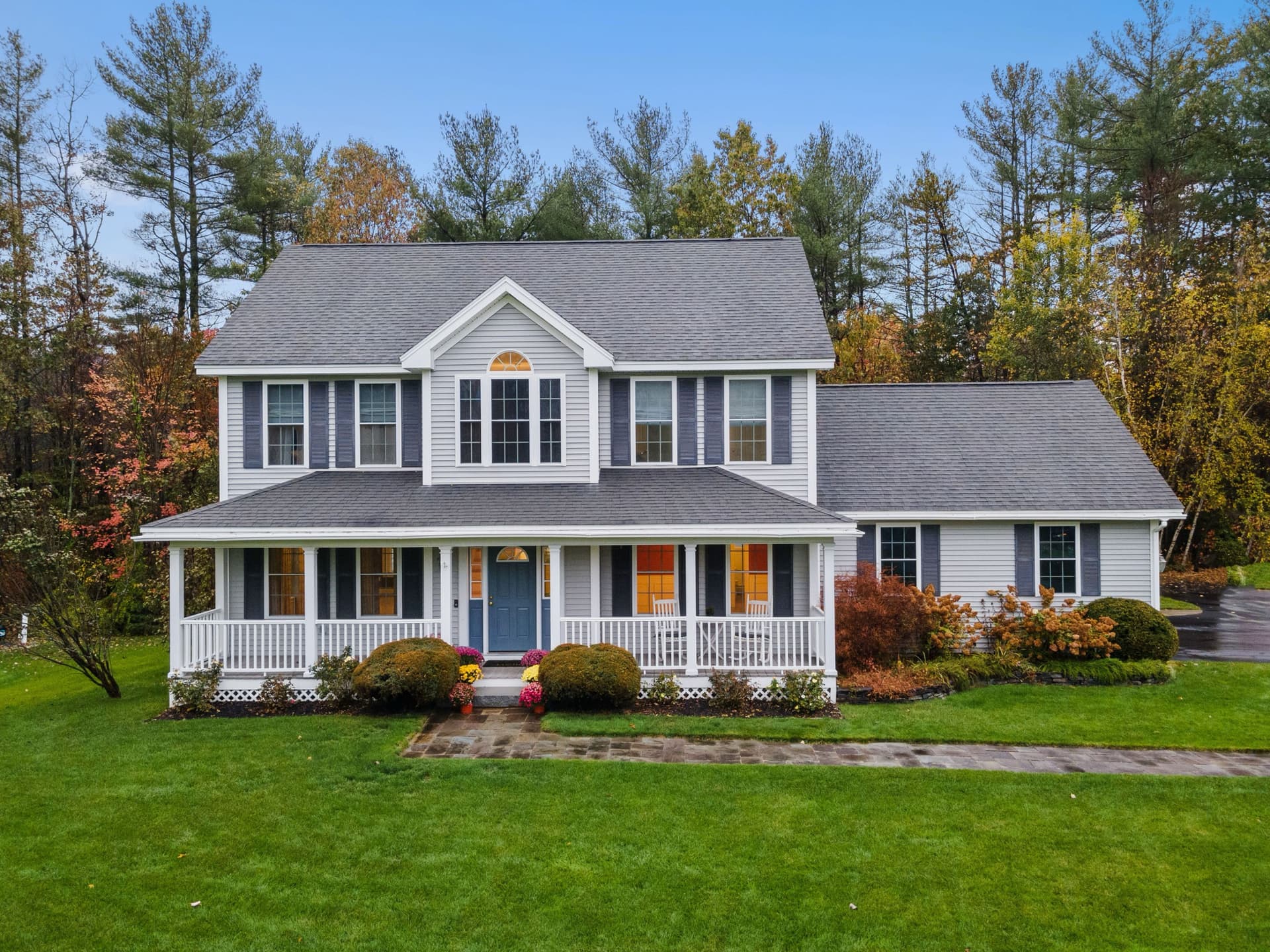 Paver walkway leading to a New England colonial home